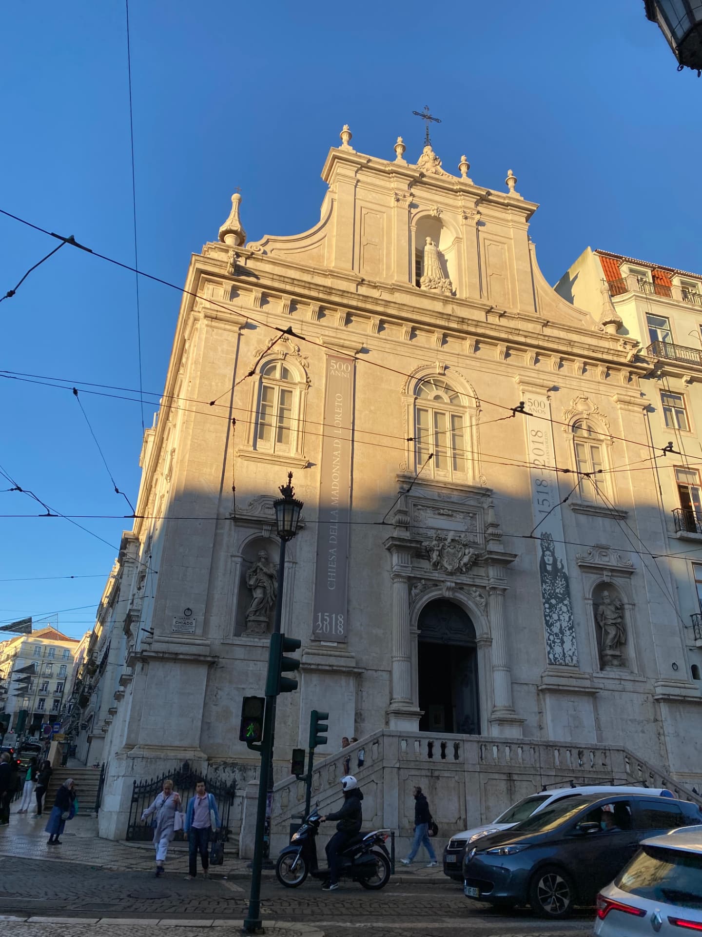 The white façade of a grand Lisbon church under blue sky
