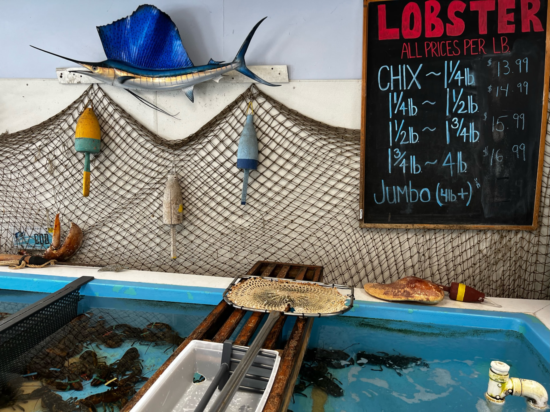 Lobster market with a handwritten price board and fishing décor