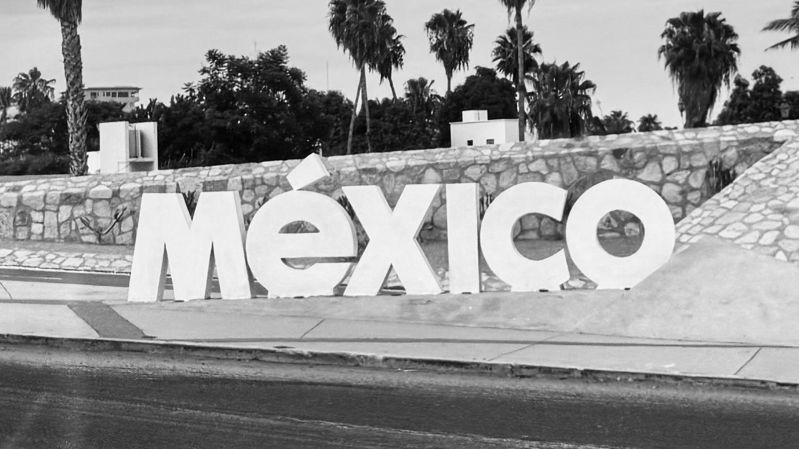 Large México letters beside a palm-lined road in Baja California Sur