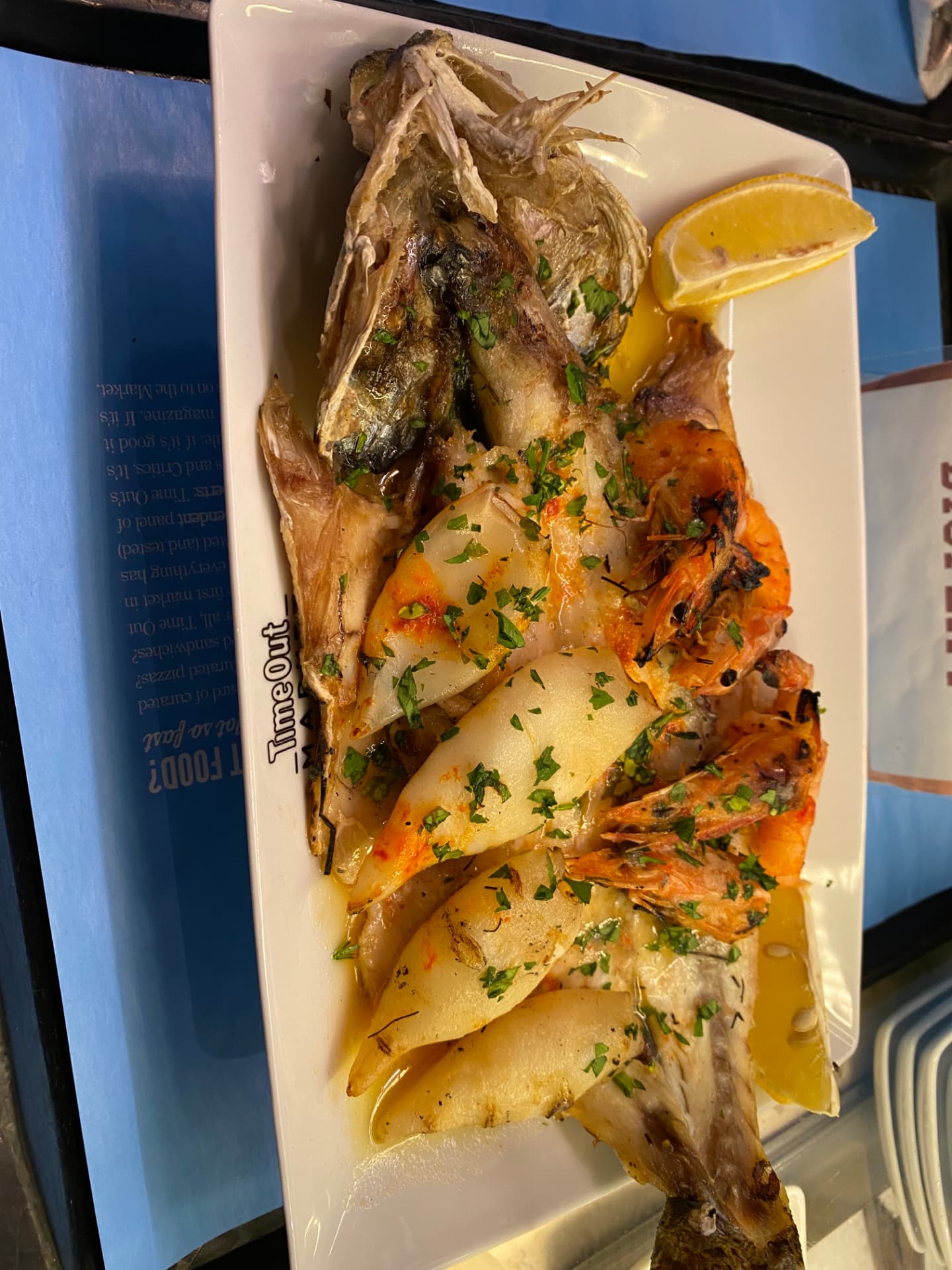 A whole grilled fish served on a white plate