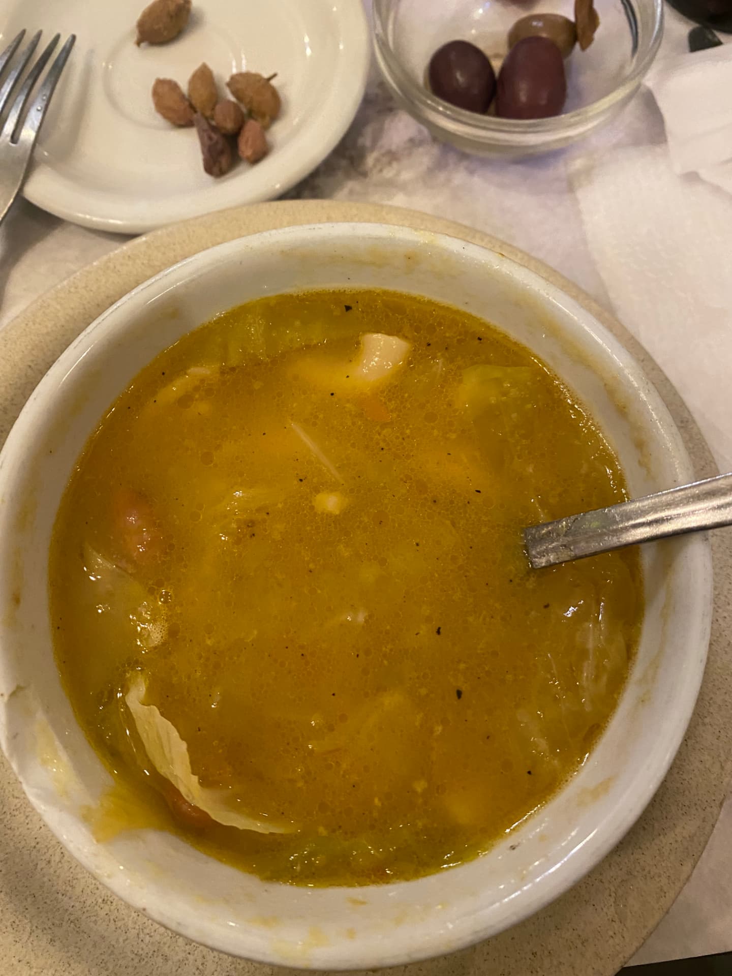 A bowl of yellow soup on a restaurant table