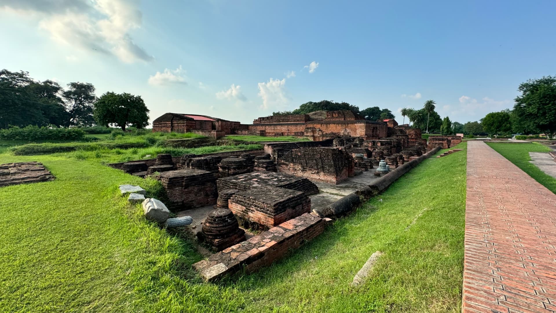 A brick path follows the edge of the excavated monastic ruins. — Nalanda, Bihar, India · Patna chapter.