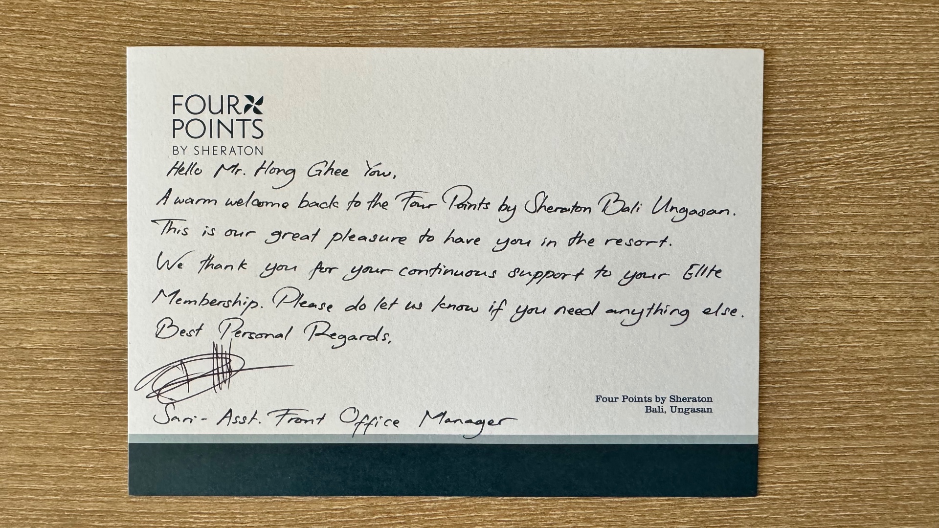 A handwritten welcome card from Four Points by Sheraton Bali Ungasan on a wooden table