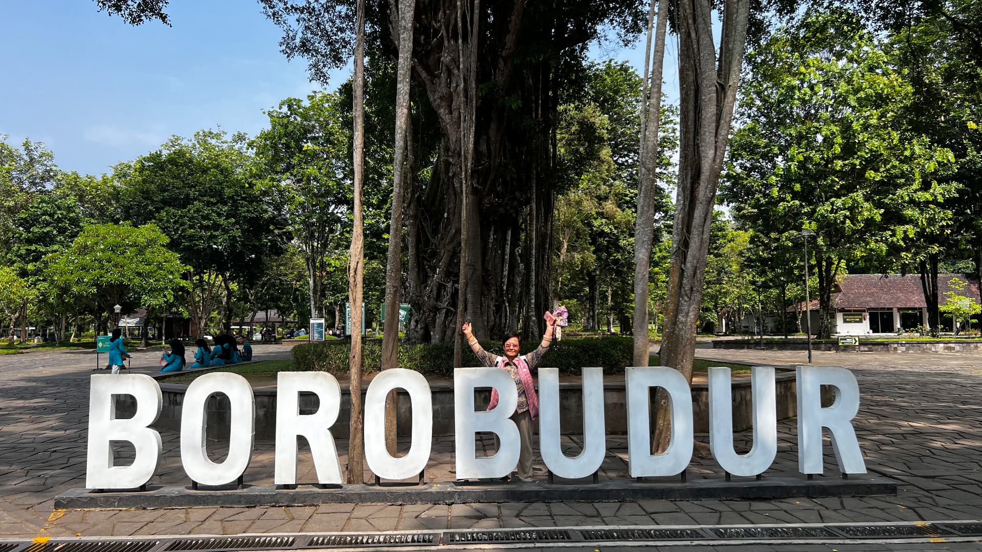 Traveler posing behind the large Borobudur letters at the entrance