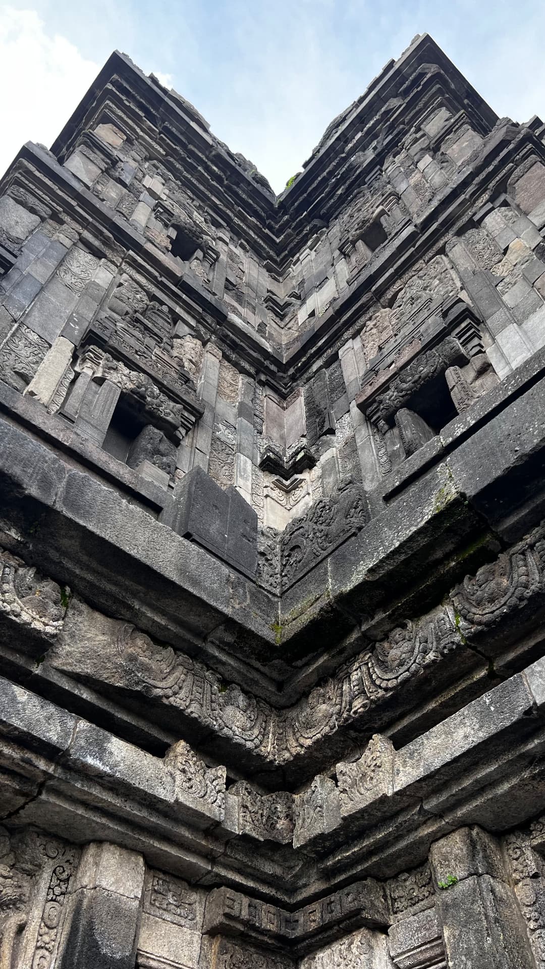Carved stone corner of a Prambanan temple viewed from below