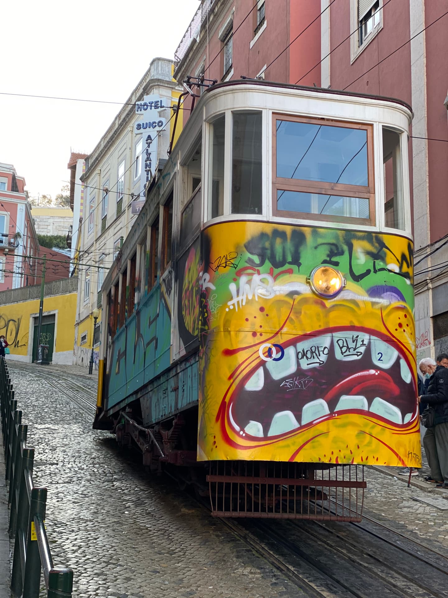 A graffiti-covered tram standing on a steep track