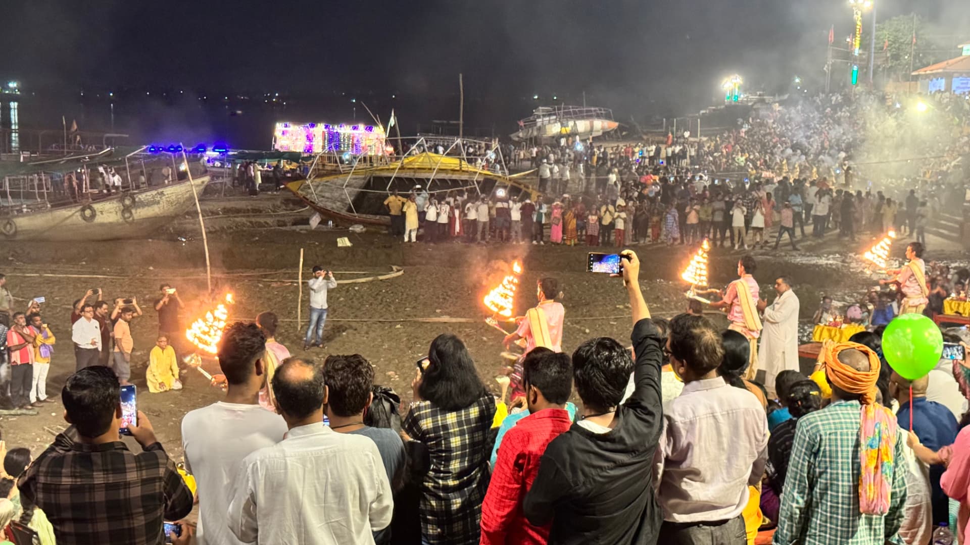 The riverfront ceremony fills the night with lamps, smoke and people. — Varanasi, Uttar Pradesh, India.