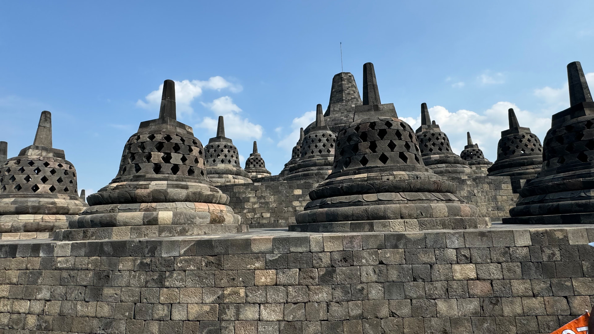 Rows of bell-shaped stupas beneath a clear blue sky