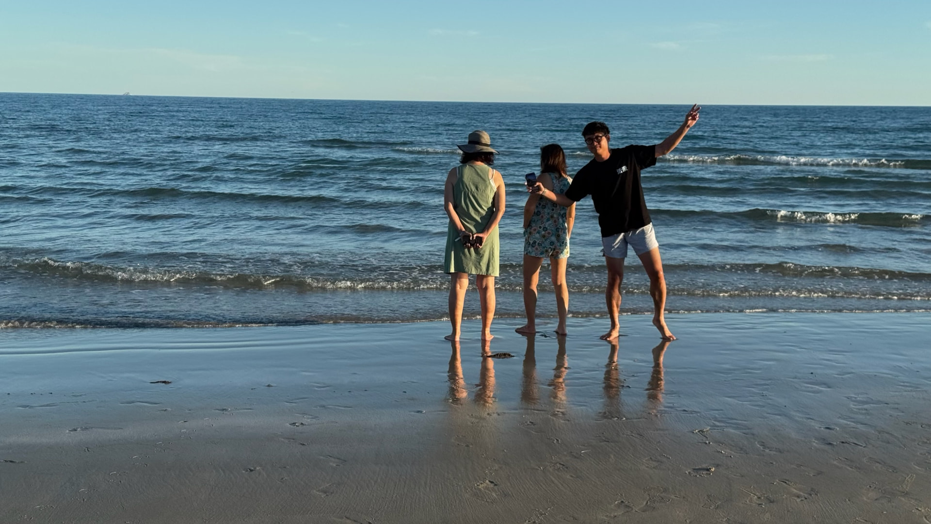 Three family members standing ankle-deep in the Sea of Cortez