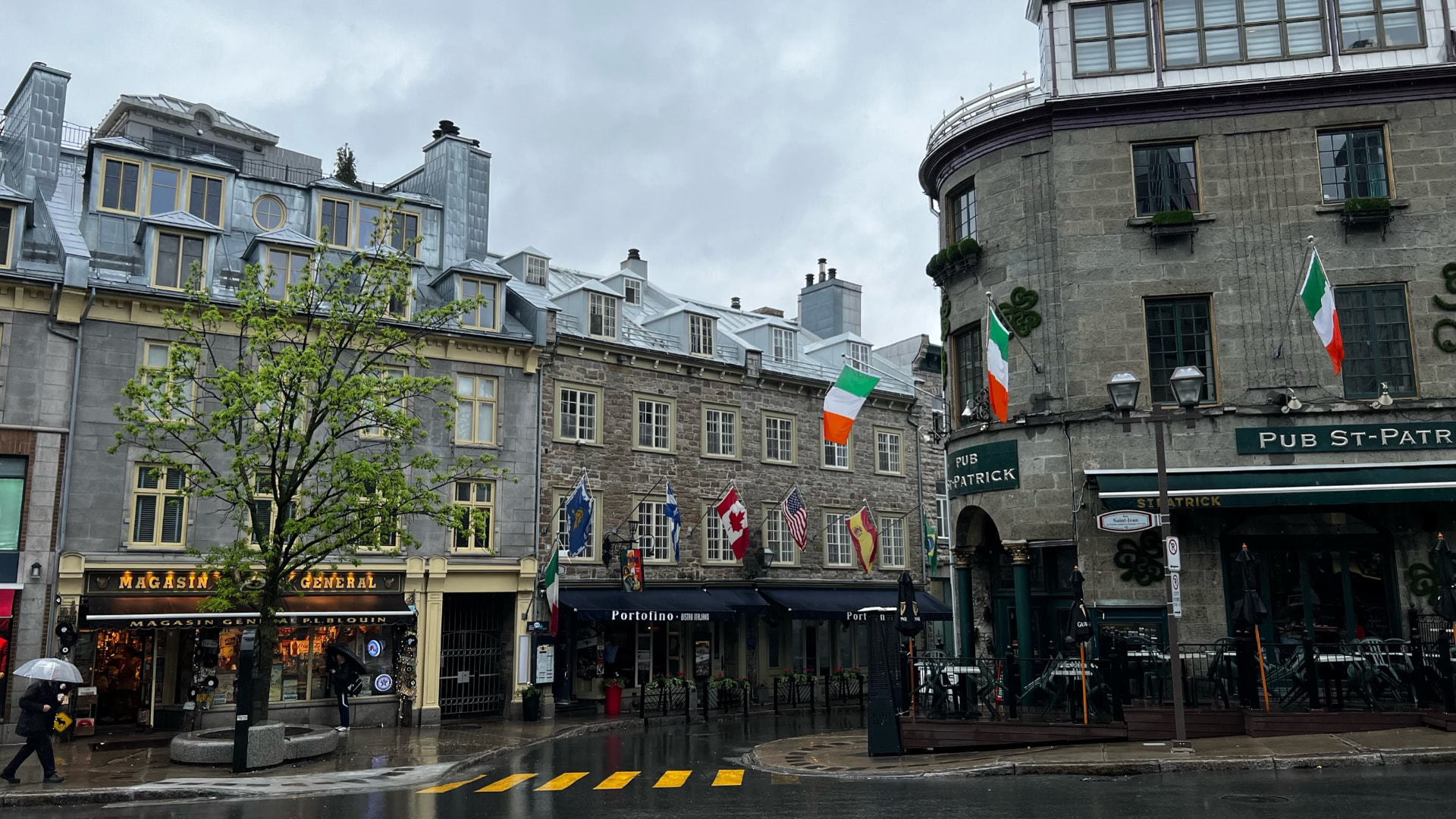 Historic stone buildings and cafés on a rainy Québec City corner