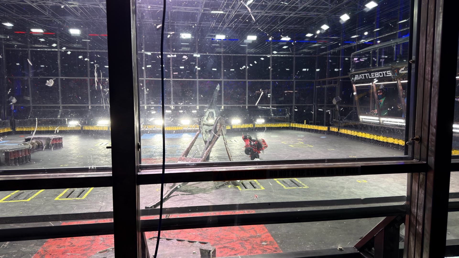 Two robots fighting inside the scratched arena glass