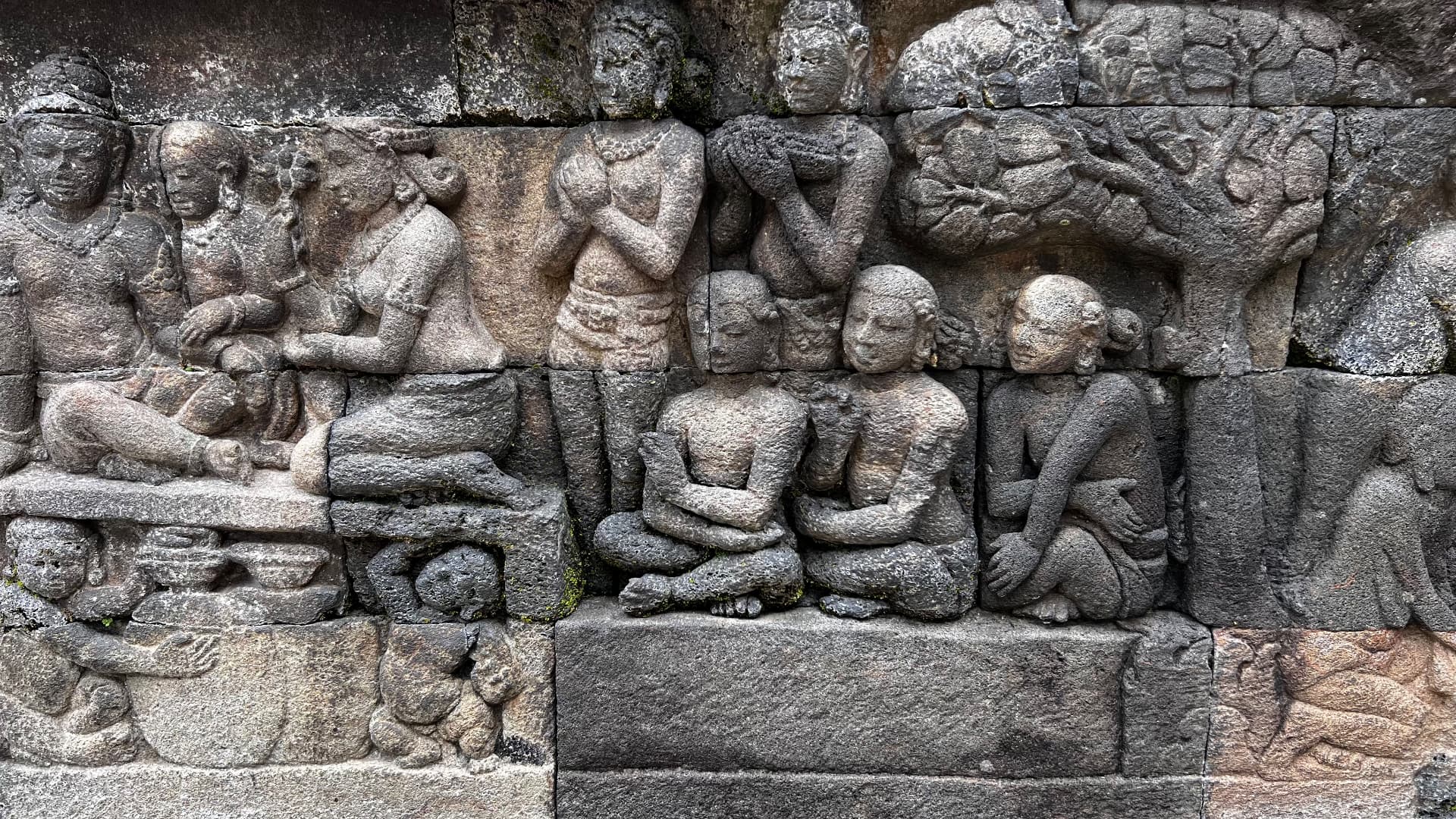 Stone relief depicting figures carved along the temple wall