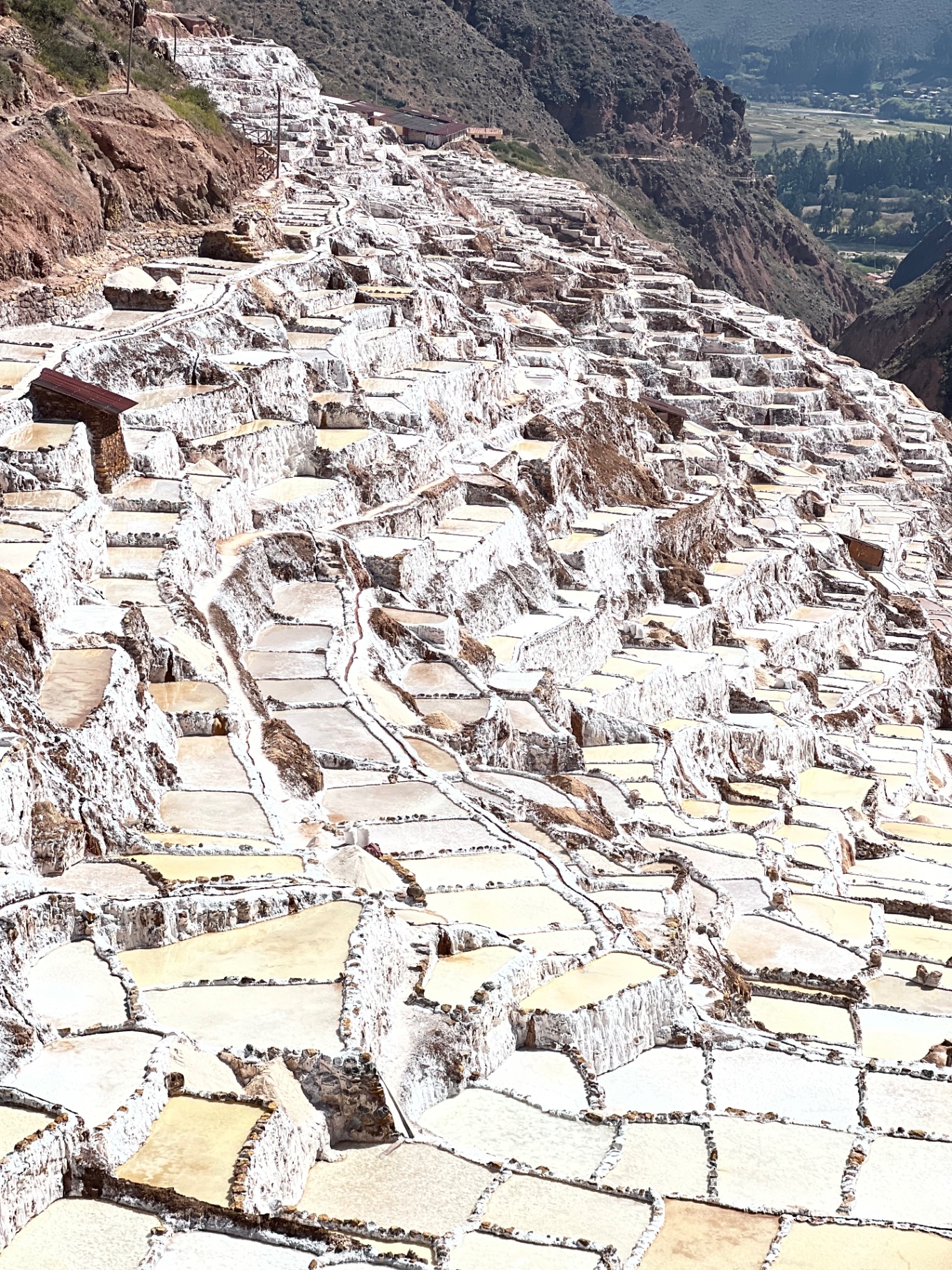 Steep overview of hundreds of white salt pools at Maras