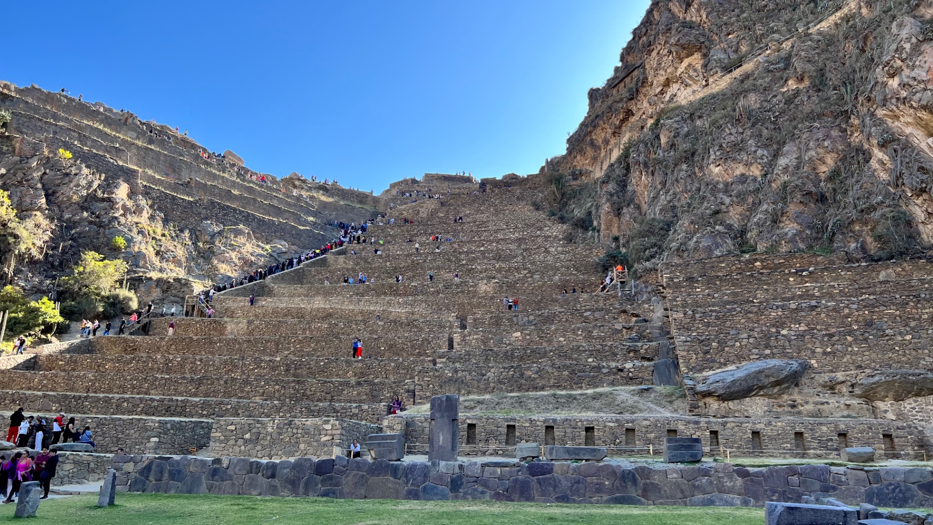 Wide view of Ollantaytambo's terraces beneath towering cliffs