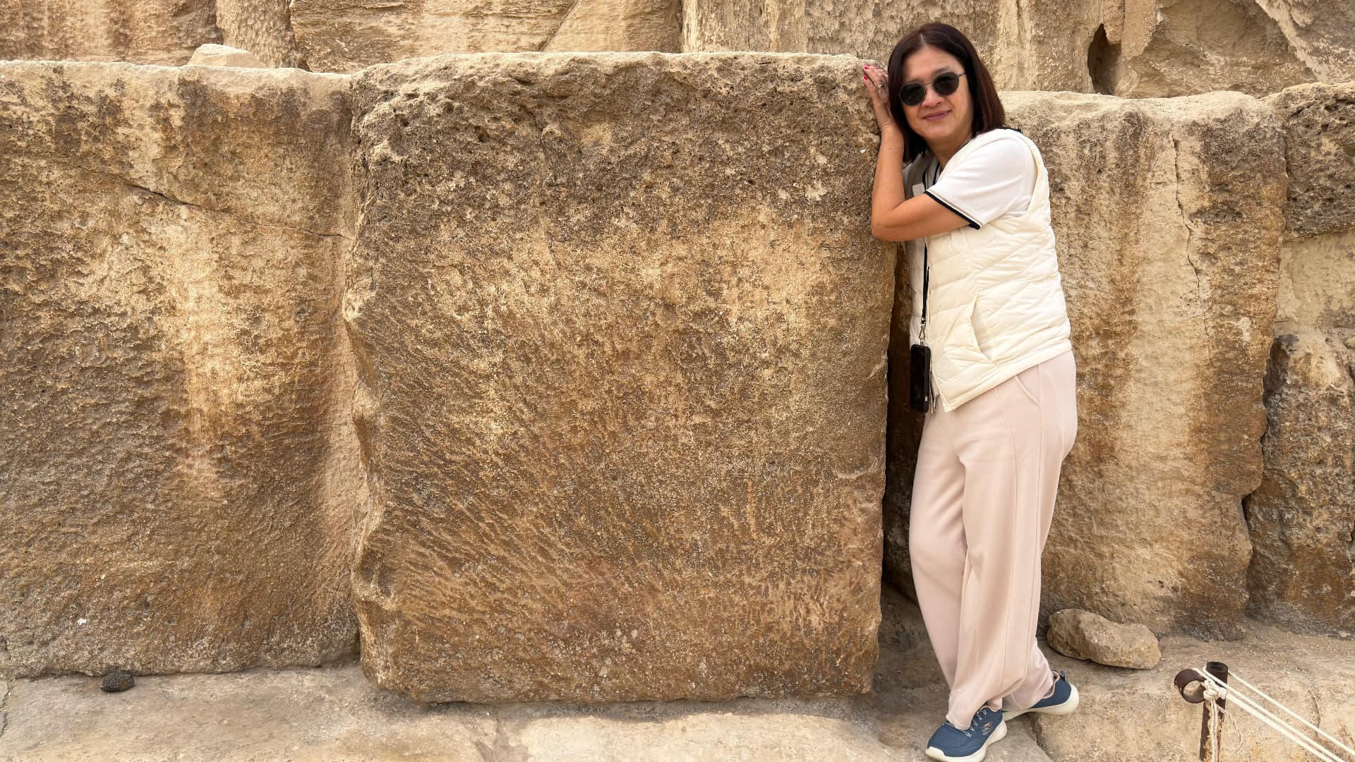 Becky leaning against a single limestone block nearly as tall as she is