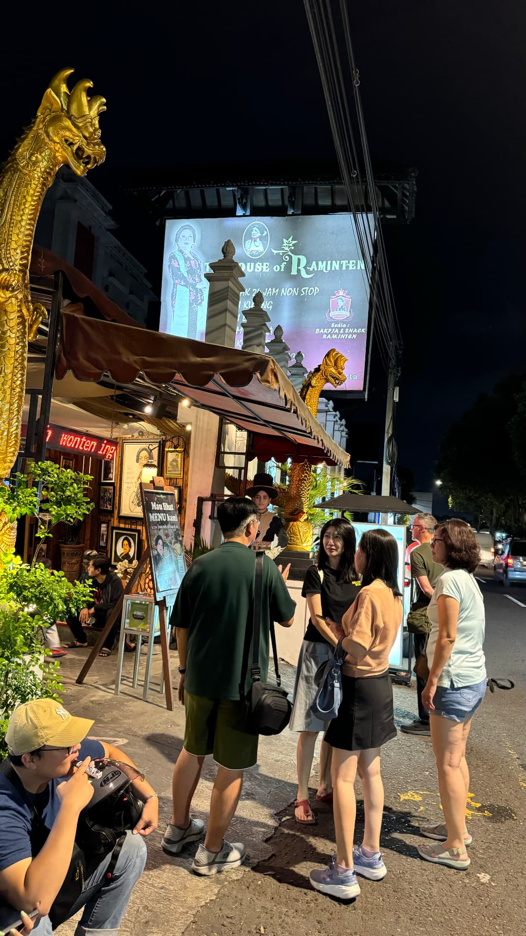 Companions standing outside the House of Raminten at night