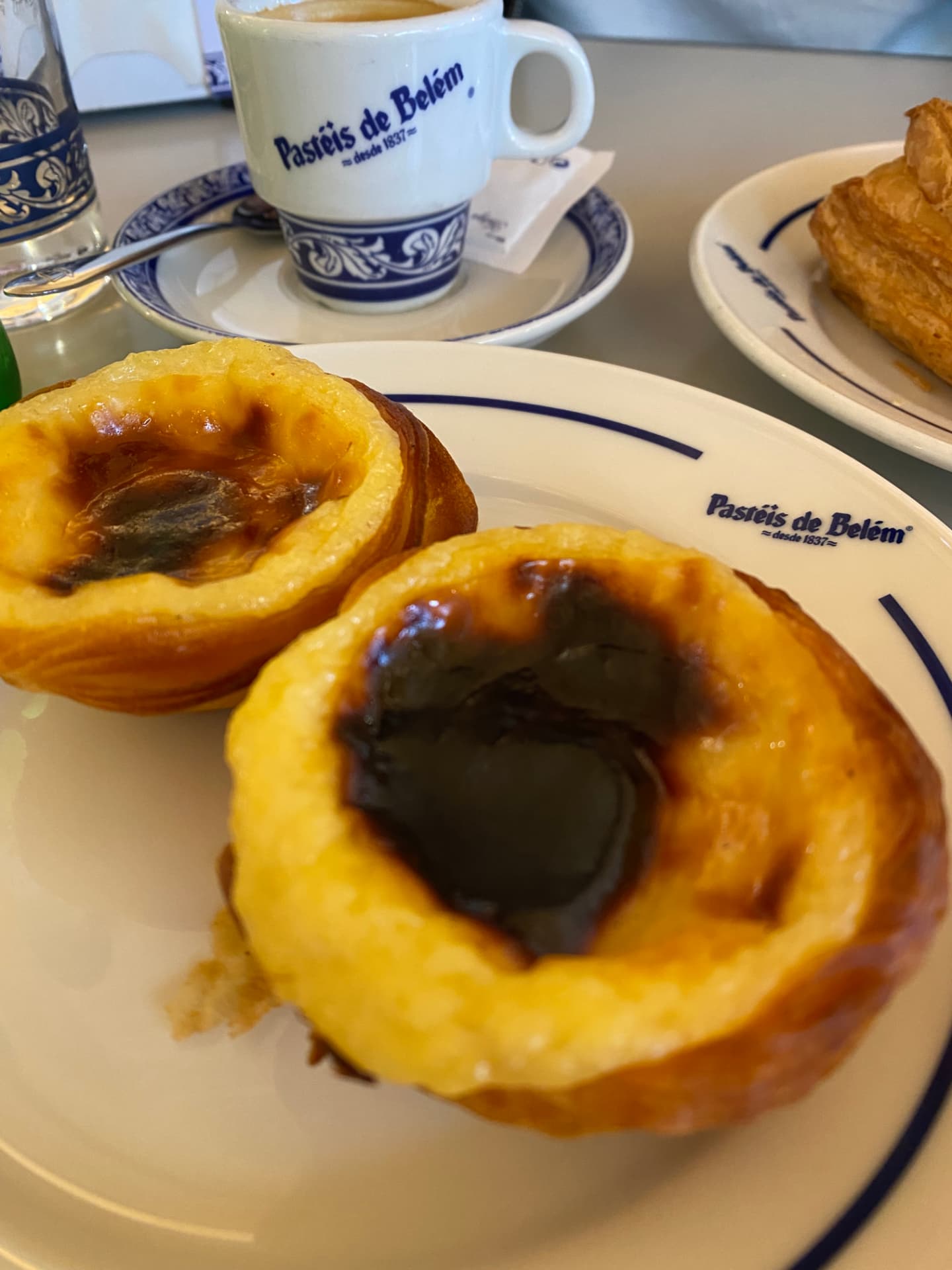 A custard tart and a coffee close together on a table