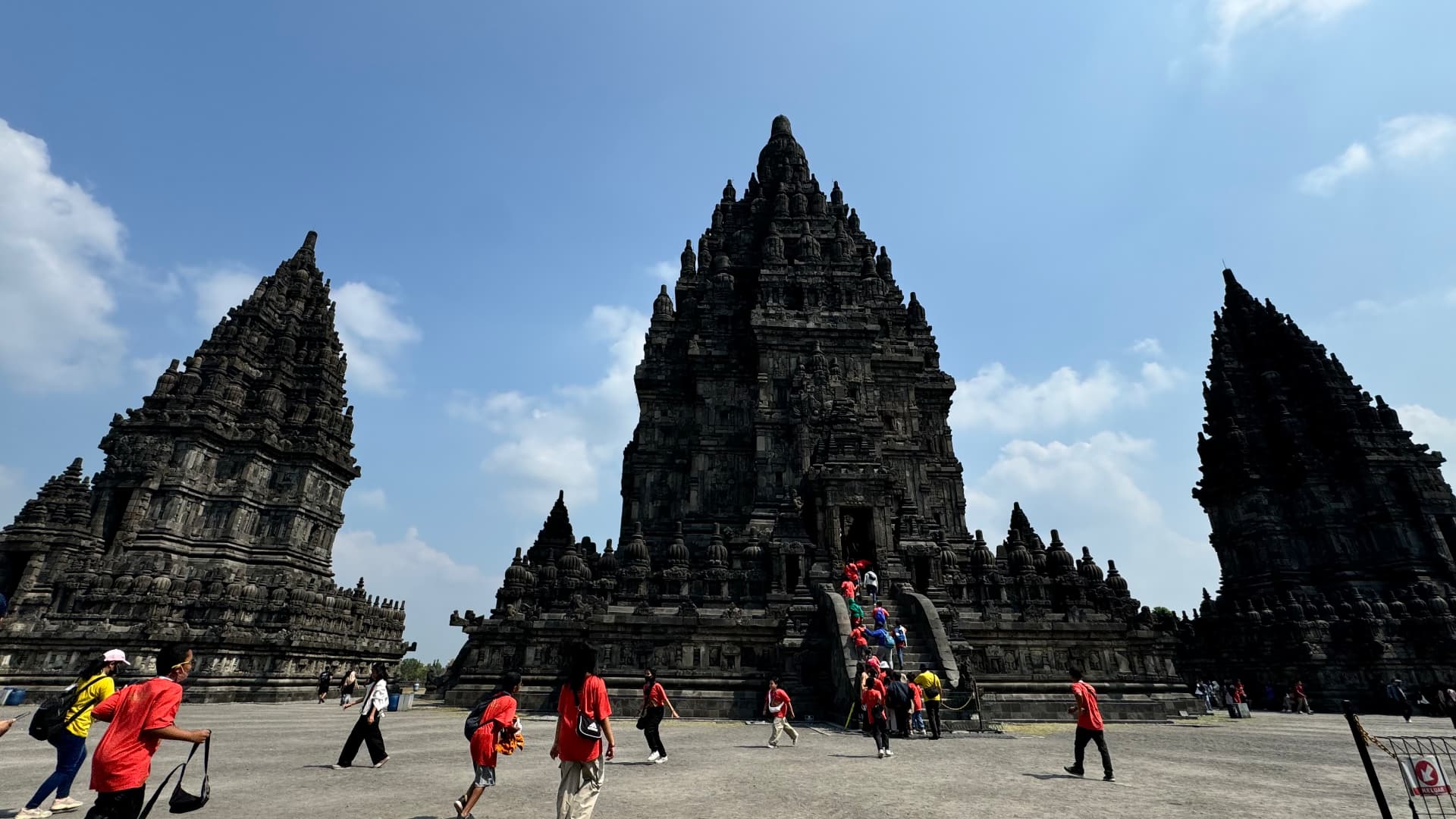 Visitors walking toward the central temples at Prambanan