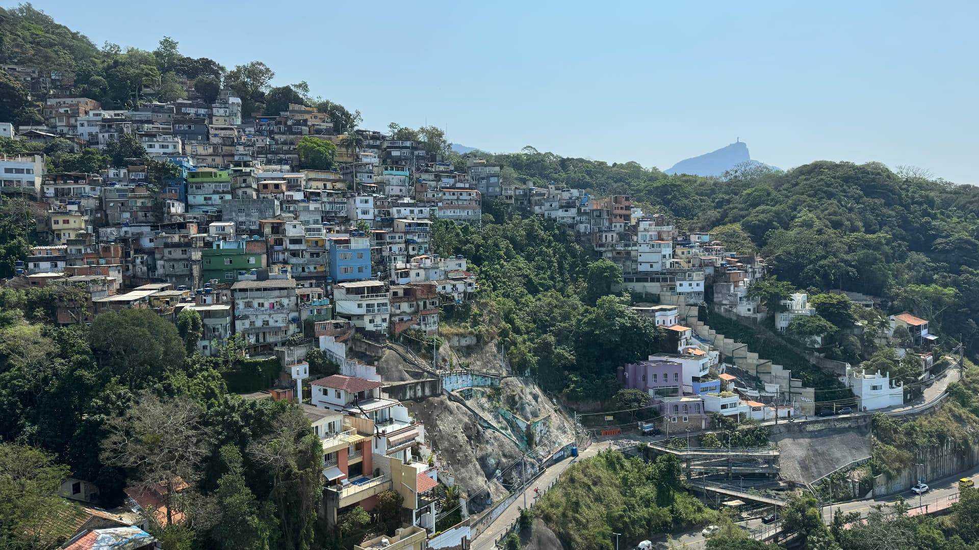 Colourful hillside houses with Christ the Redeemer visible on a distant peak