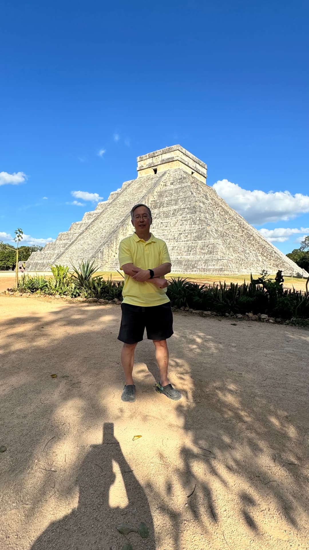 Traveler standing in the shade with El Castillo behind him
