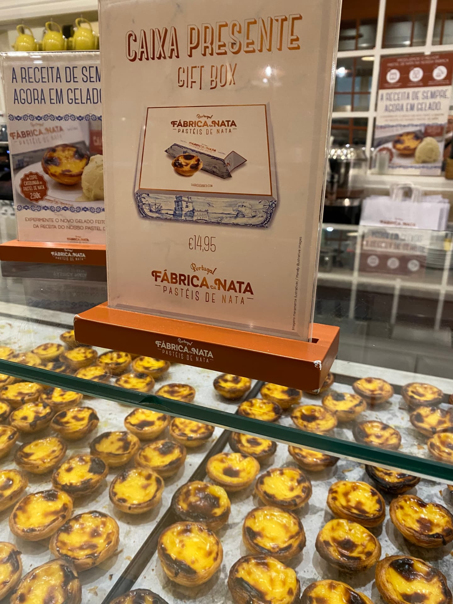 A bakery display case filled with rows of pastéis de nata