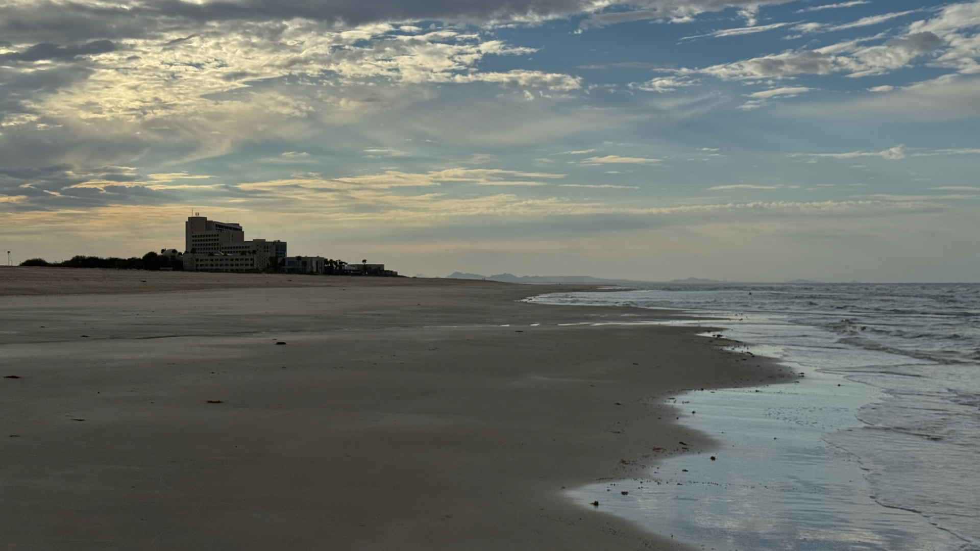 Quiet beach beneath a layered evening sky
