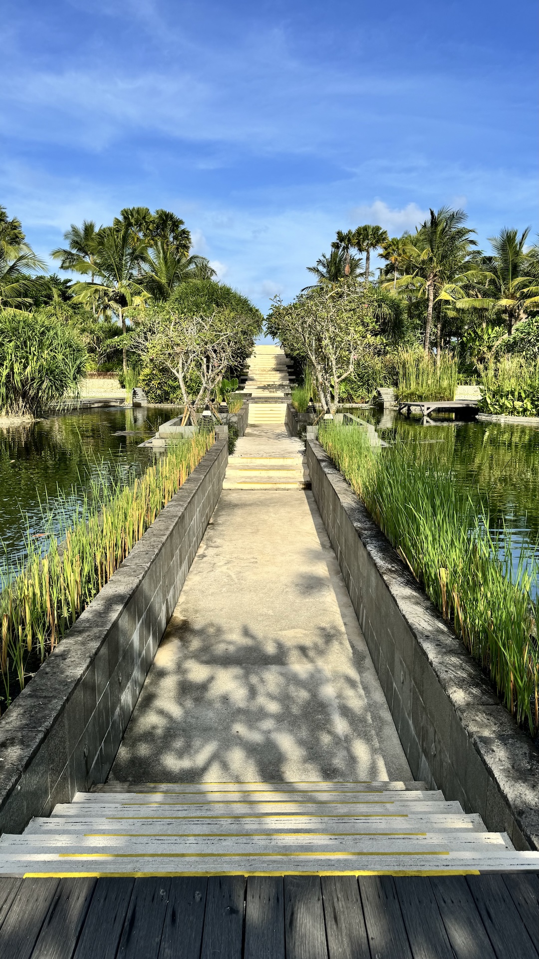 Garden causeway between reflecting ponds leading toward the sea