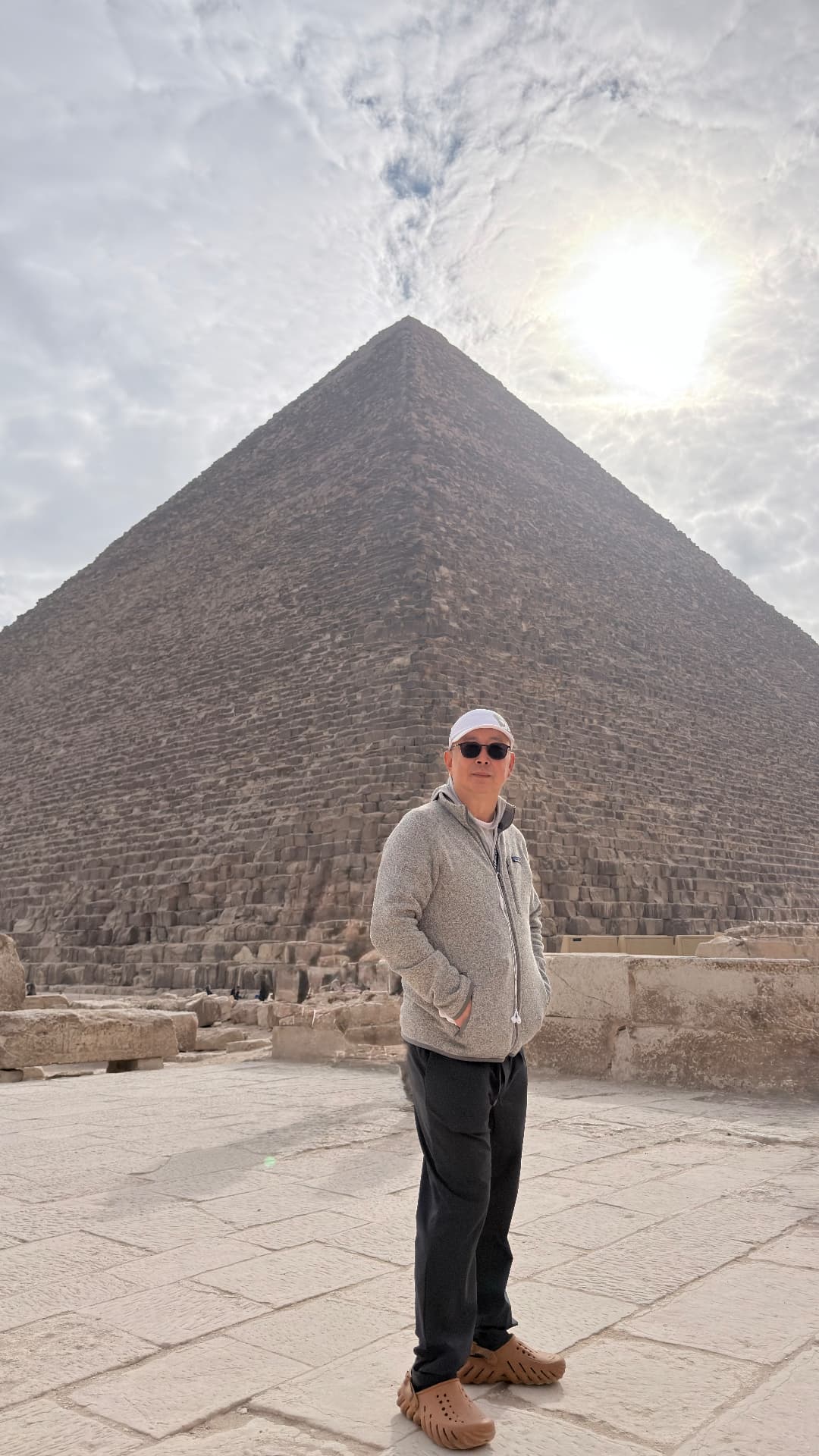 Ken standing before the Great Pyramid with the sun flaring above its shoulder