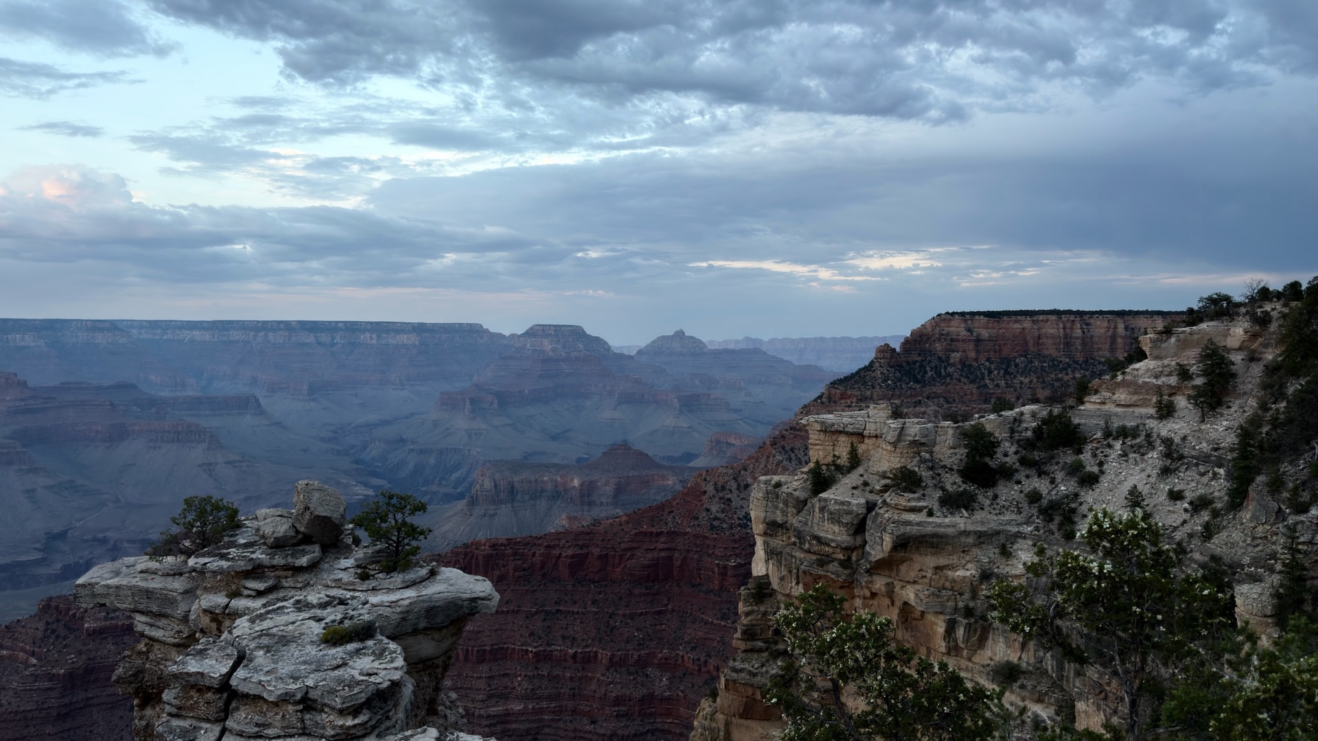 Wide view of the Grand Canyon at dusk under heavy cloud