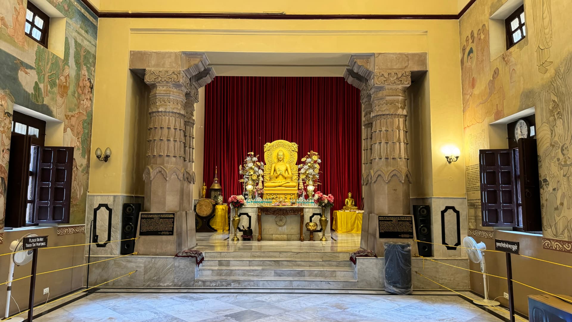 The temple’s golden Buddha sits before a deep red curtain. — Sarnath, Uttar Pradesh, India.
