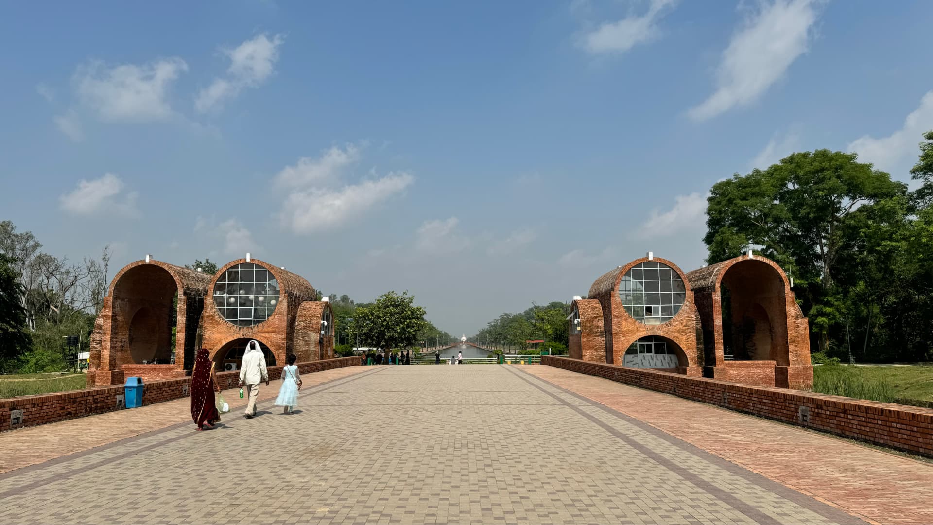 A broad walkway passes between decorative gateways in the pilgrimage grounds. — Lumbini, Nepal.
