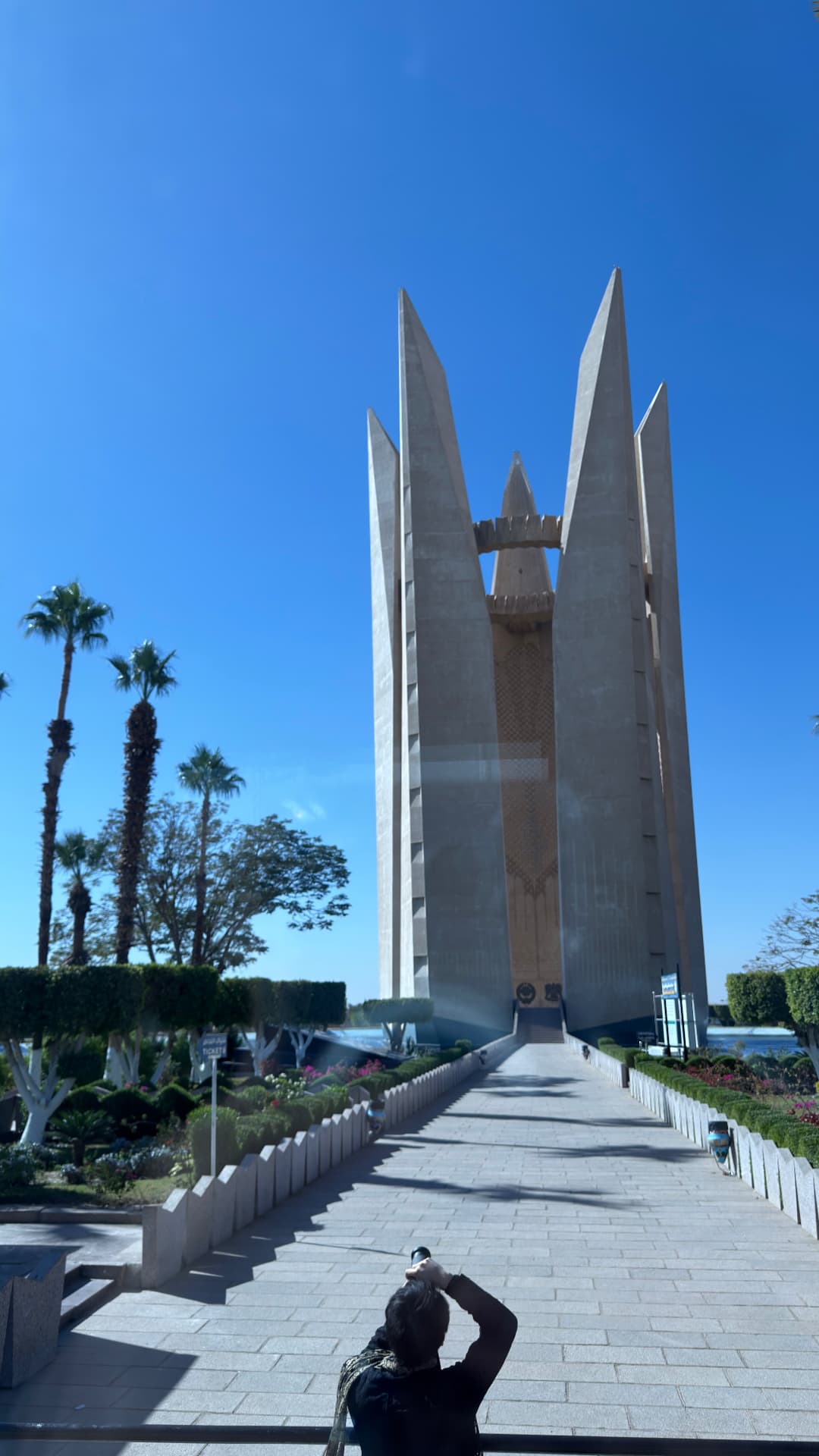 The tall concrete lotus monument at the Aswan High Dam against a clear blue sky