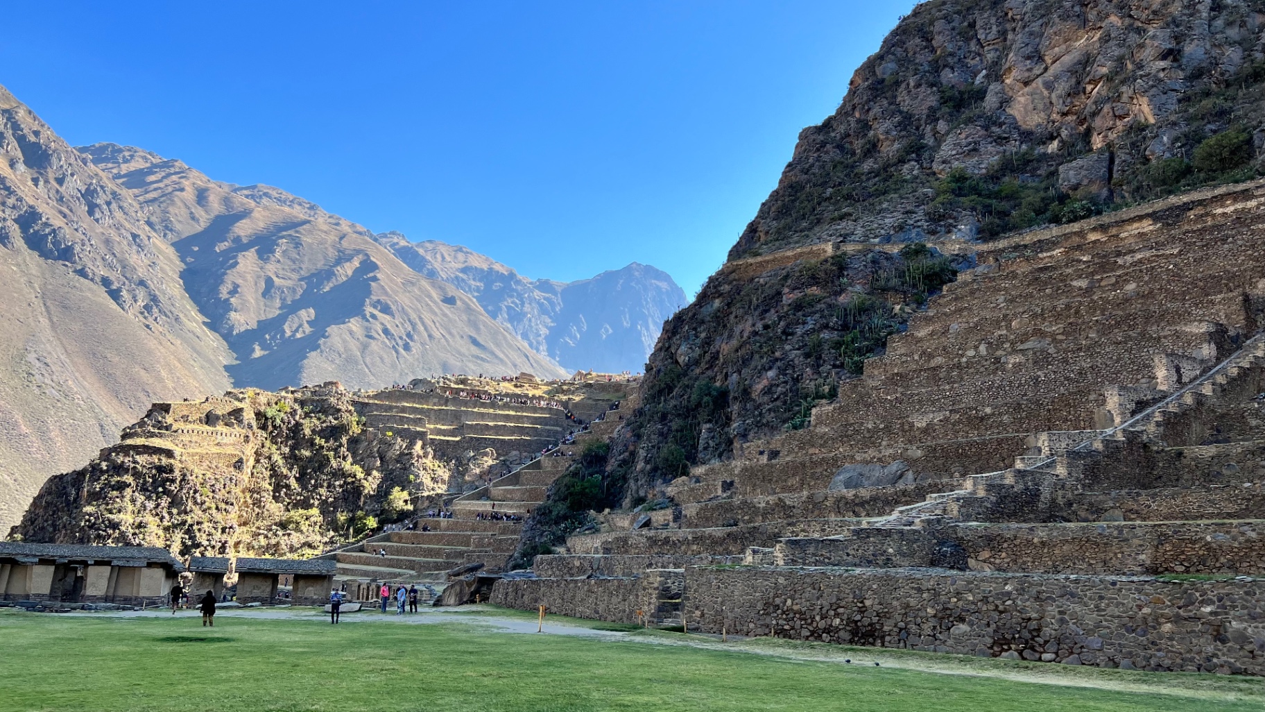 Wide green lawn, terraces, and mountains at Ollantaytambo