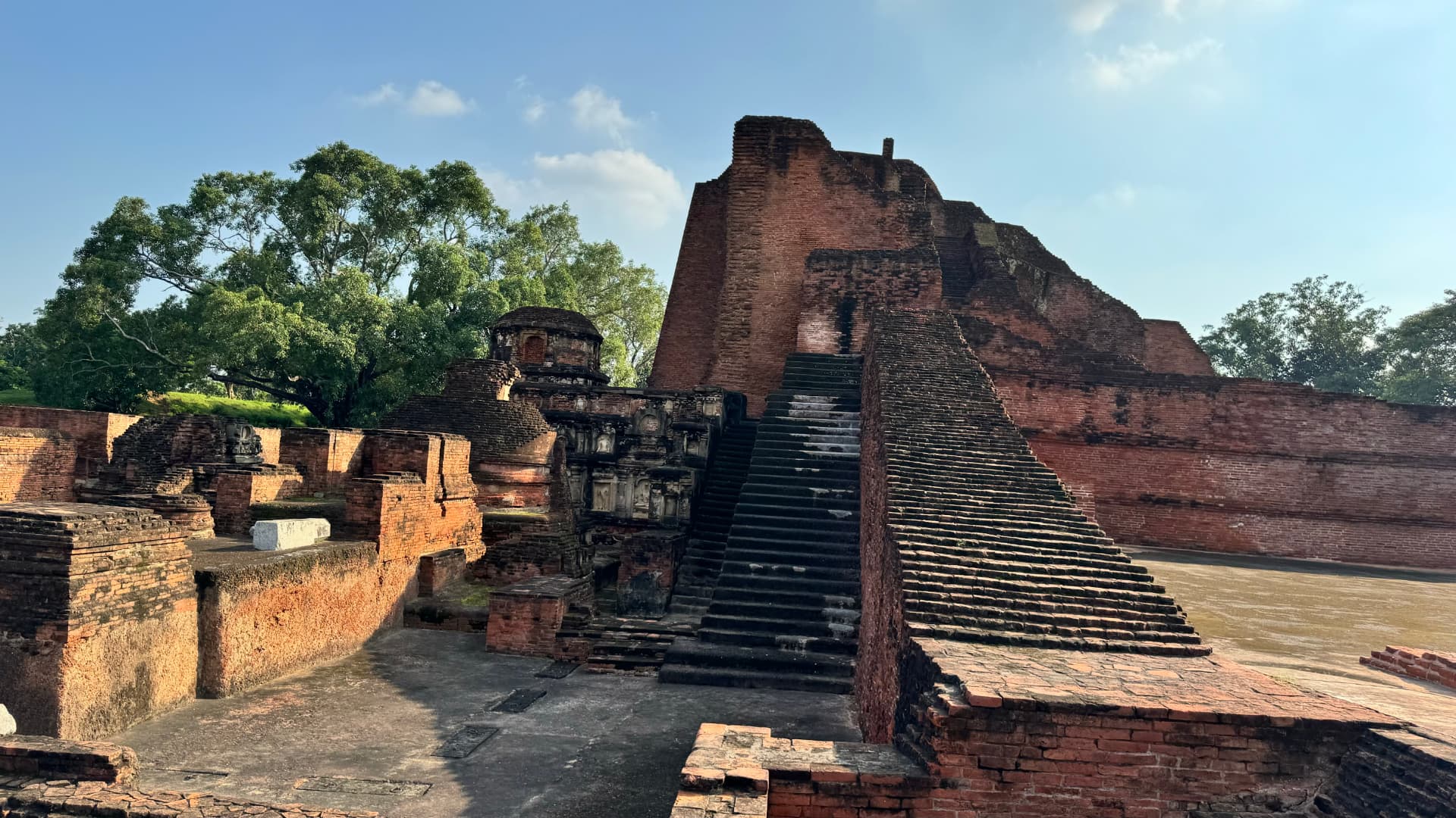 Steps lead up between the tall brick structures of the archaeological site. — Nalanda, Bihar, India · Patna chapter.