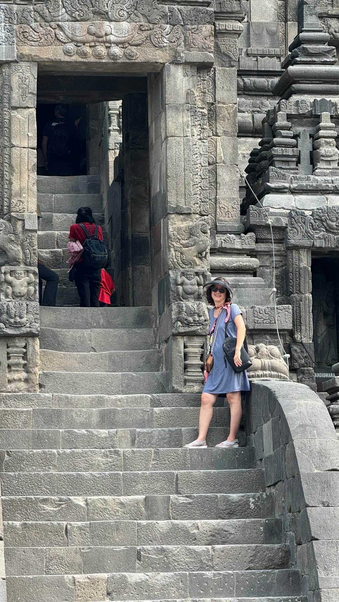 Traveler smiling beside the stone steps at Prambanan