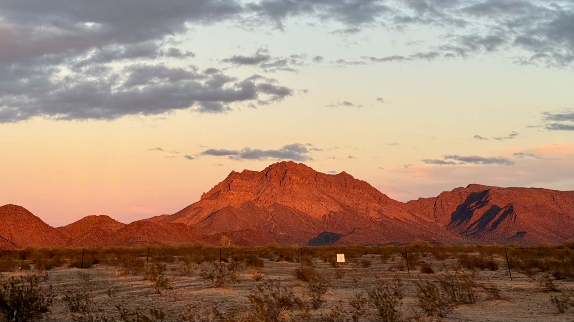 Desert mountain glowing red at sunset