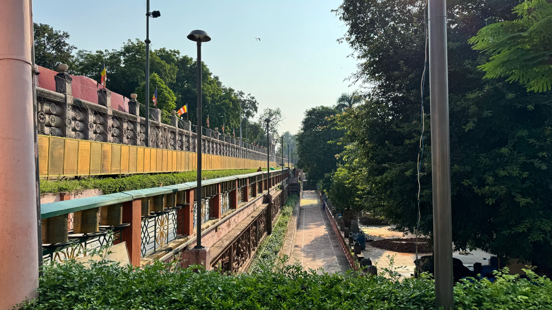A tree-shaded passage alongside the temple grounds. — Bodh Gaya, Bihar, India.
