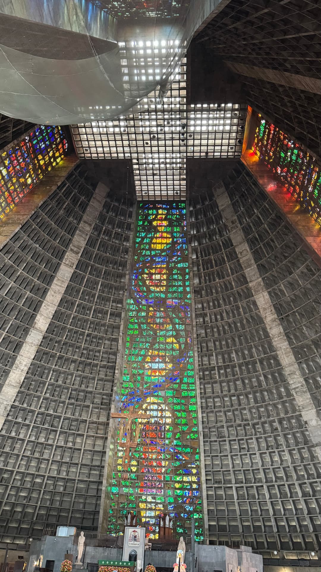 Vast curved concrete interior and luminous stained glass inside the cathedral