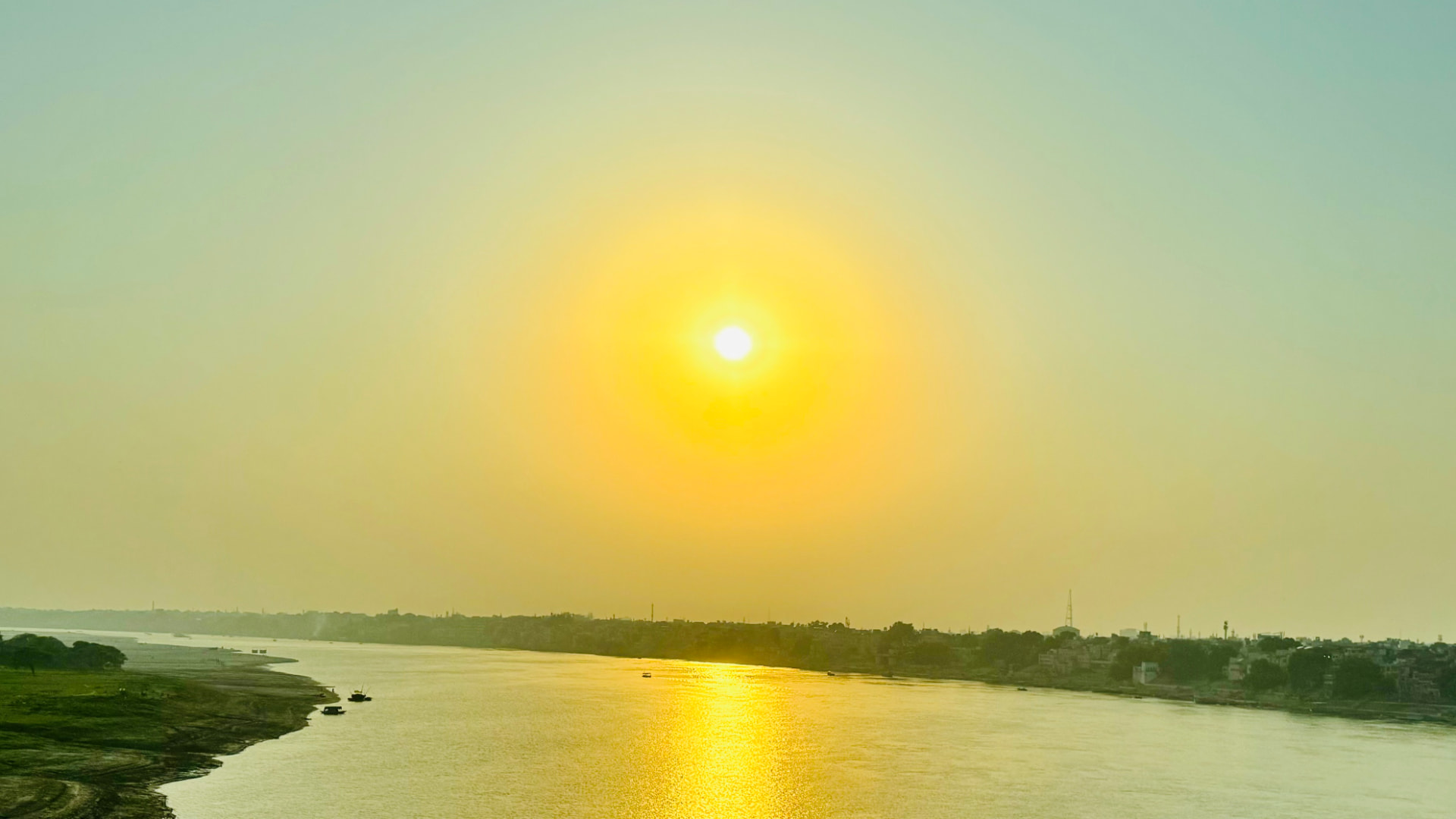 The low sun casts a golden reflection across the Ganges. — Varanasi, Uttar Pradesh, India.