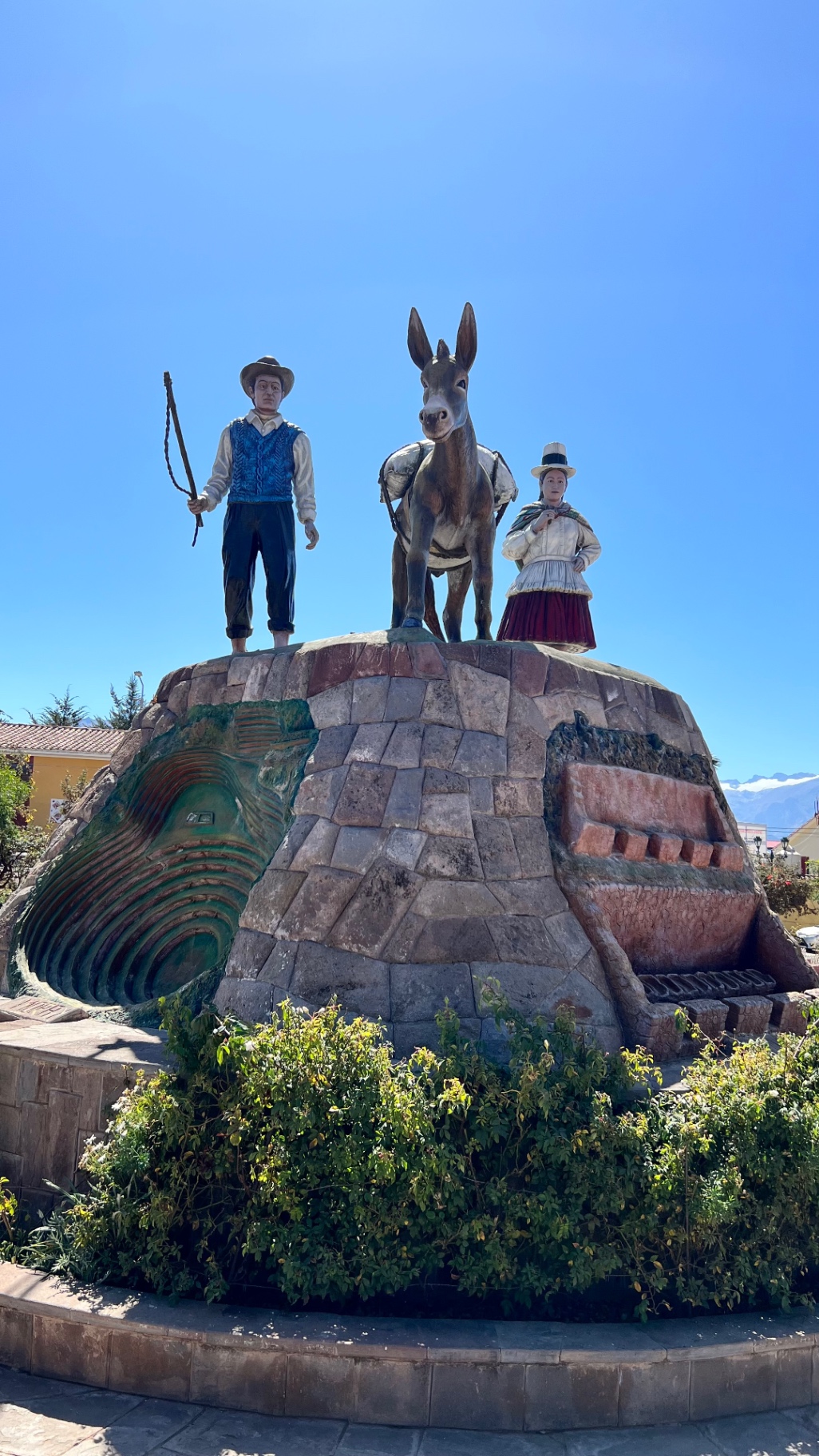 Monument to an Inca ruler and attendants against a clear sky