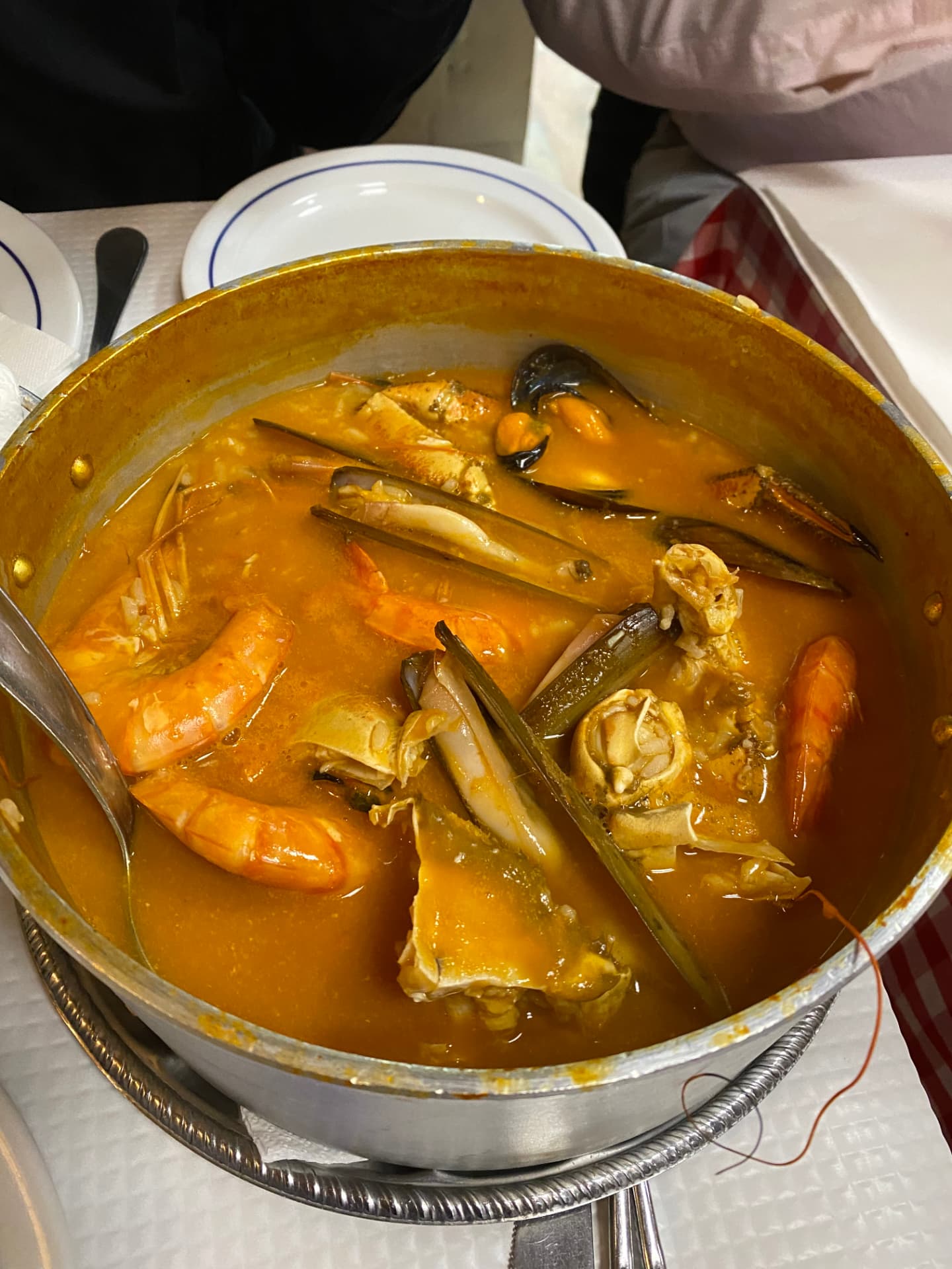A metal pot of seafood rice with mussels and prawns