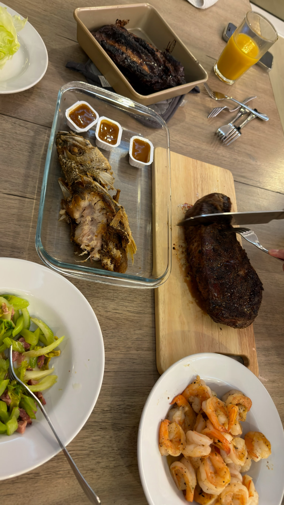 Dinner spread with grilled fish, steak, shrimp, and salad
