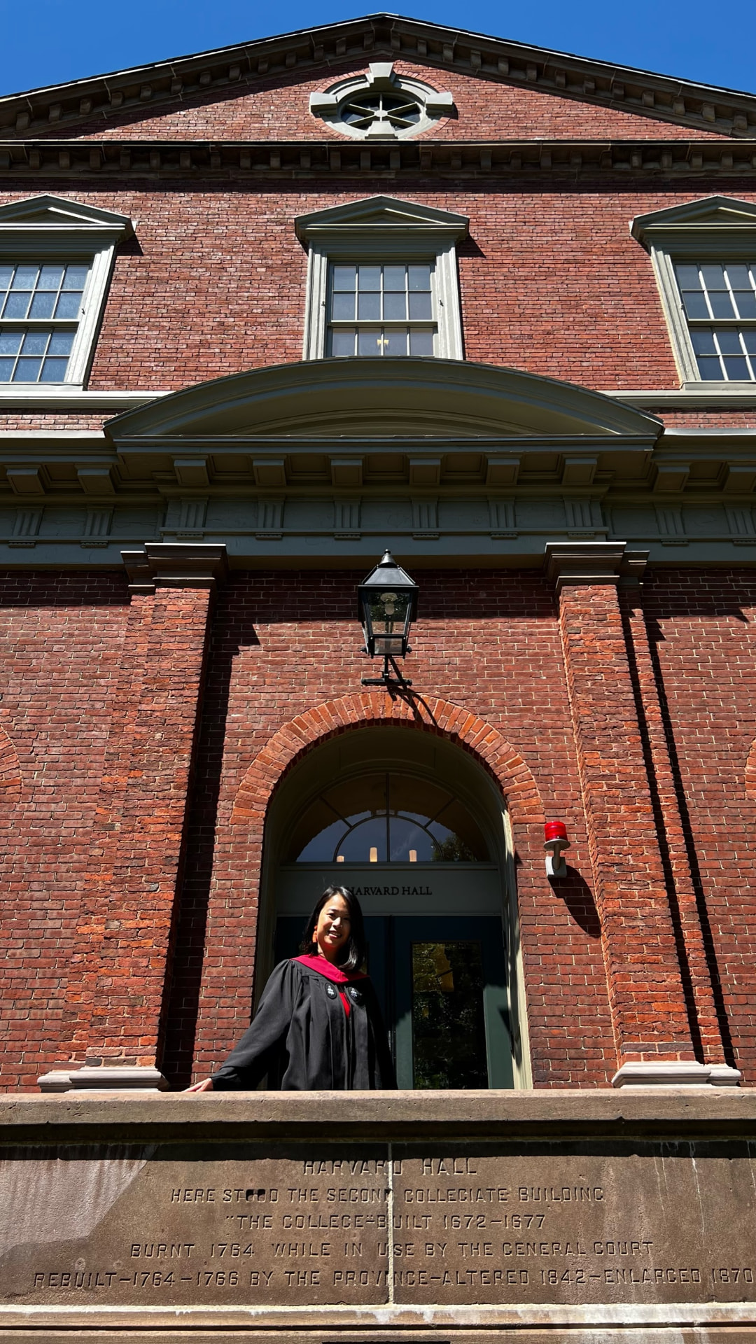 Jocelyn at the entrance of Harvard Hall, above the carved stone plaque