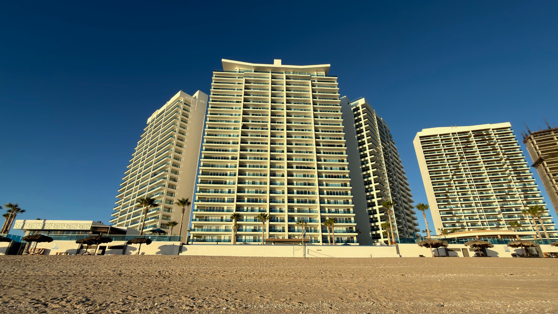 Oceanfront towers seen from the beach in warm afternoon light