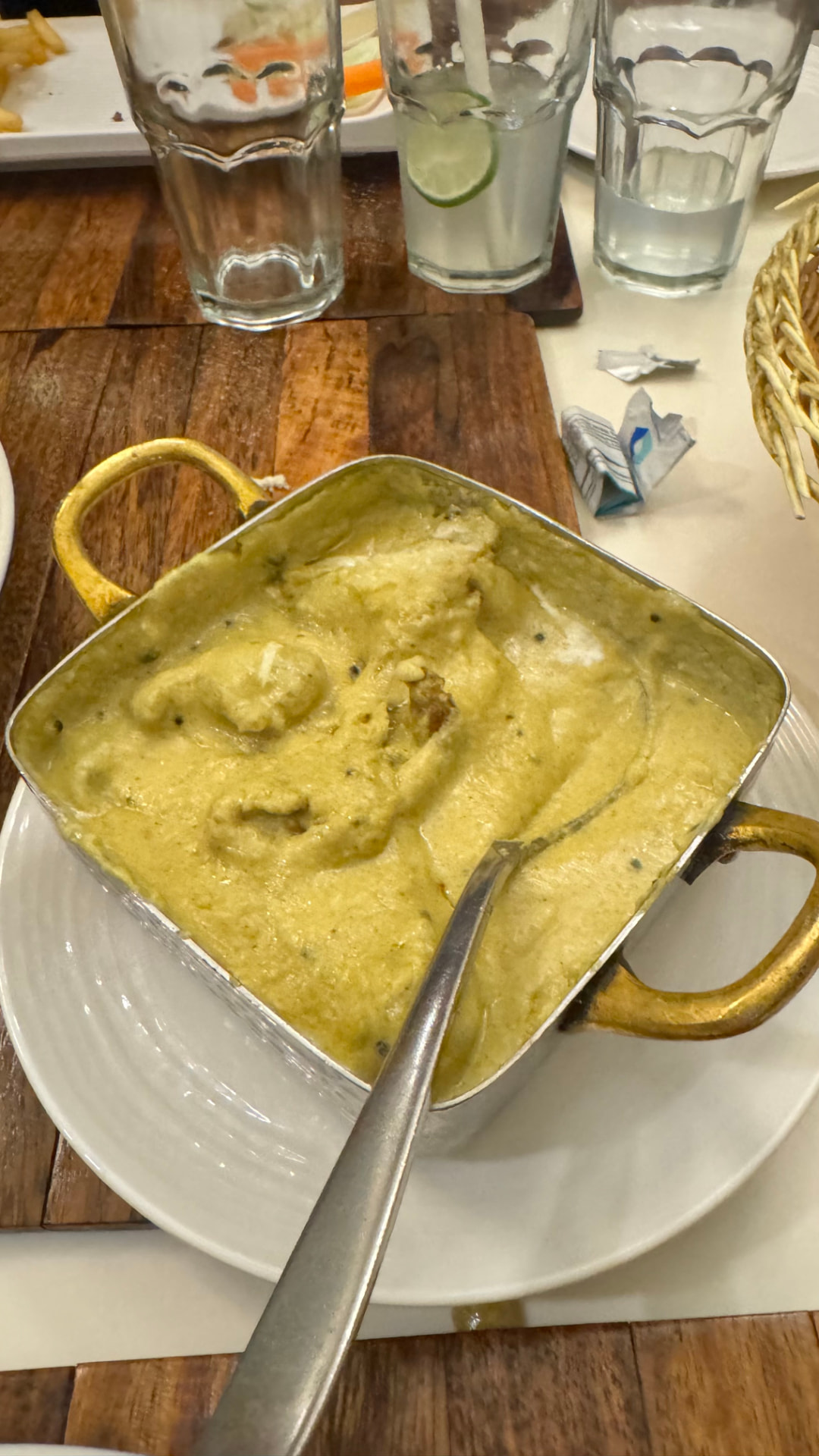A warm curry served in a metal dish during a meal stop. — Varanasi, Uttar Pradesh, India.