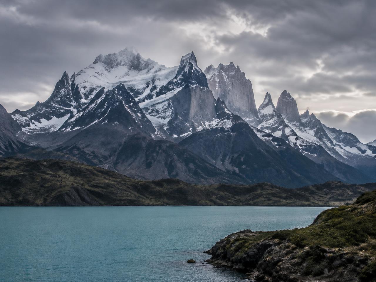 Snow-covered peaks of Torres del Paine above a blue glacial lake in Patagonia